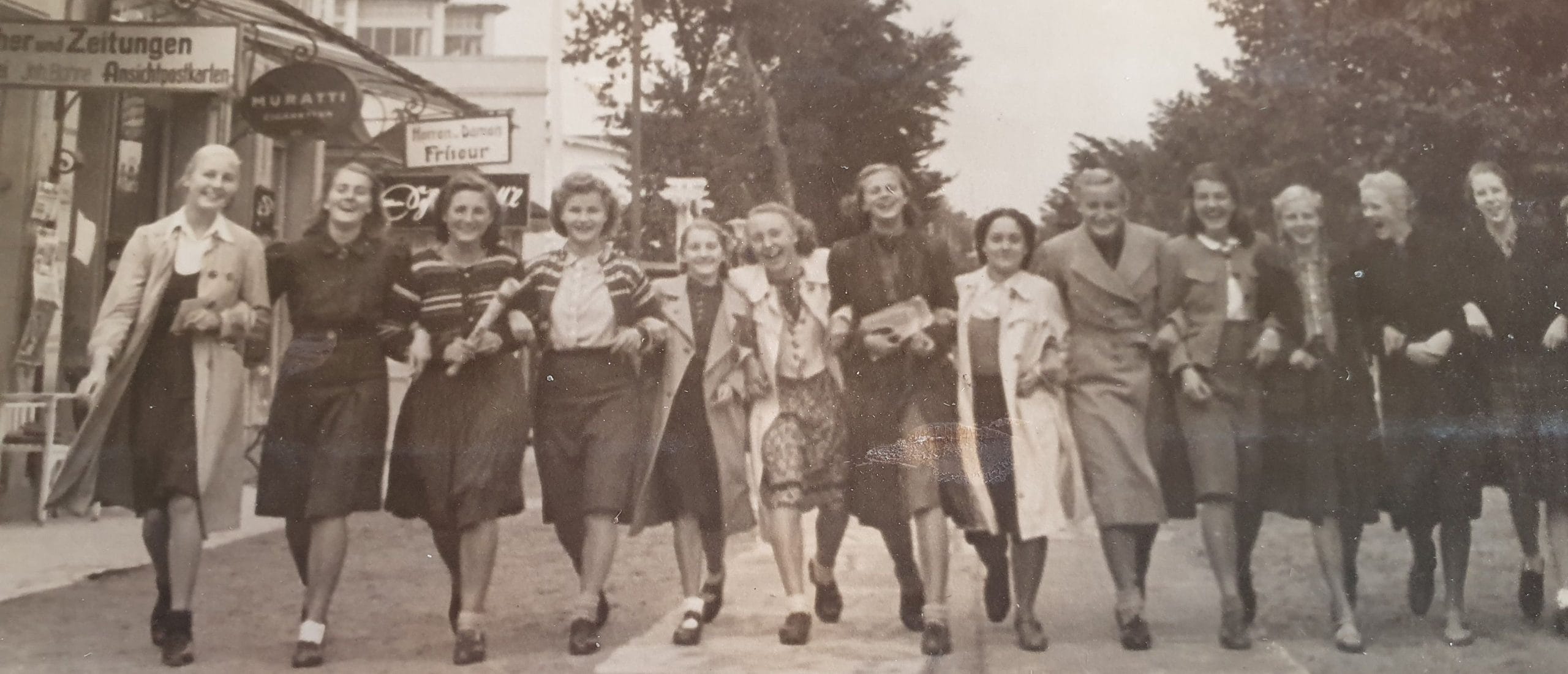 Black-and-white historical photograph of German women walking through a city street in the 1930s or 1940s, illustrating civilian life before and during World War II